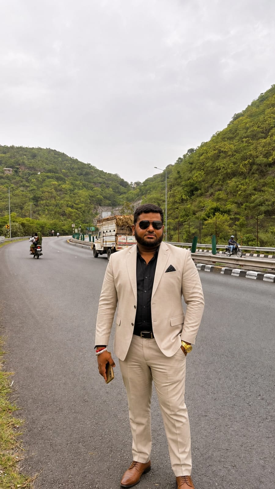 Raghav K Jha, manager at Sai Ram Developers, photographed in a light suit on a highway near the site.